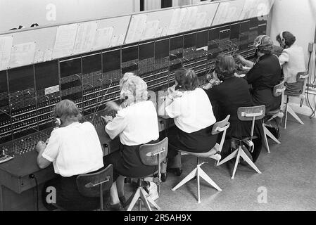 Téléphonie dans le 1950s. Les femmes travaillant à un standard téléphonique comme ses opérateurs. Un système de communication téléphonique qui a été actionné manuellement où les appels entrants ont été renvoyés et redirigés vers un autre numéro de téléphone par l'opérateur, dans ce cas localement dans le bâtiment desservant une entreprise ou une organisation avec de nombreuses lignes téléphoniques internes. L'opérateur du standard peut prendre des messages et vous mettre en attente si la ligne était occupée. Suède 1953. Kristoffersson réf. 2A-34 Banque D'Images