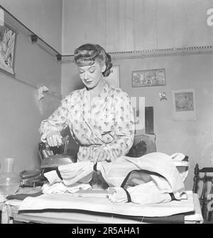 Repassage dans le 1950s. Une femme a vu repasser ses vêtements. Elle est actrice Sonja Wigert 1913-1980. Suède 1951. Kristoffersson réf. BE69-5 Banque D'Images