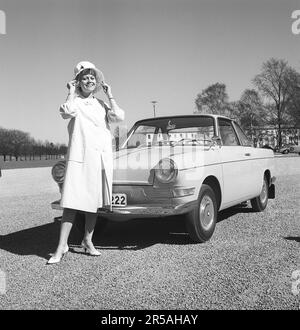 Dans le 1960s. La femme habillée à la mode se tient devant sa voiture, une BMW le jour ensoleillé du printemps. Elle est l'actrice Christina Schollin à l'extérieur de Sjöhistoriska museet à Stockholm. Suède 1962. Kristoffersson réf. CT84-7 Banque D'Images