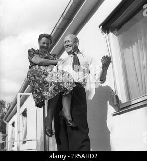 Homme fort en 1940s. Un homme un peu plus âgé démontre qu'il n'a aucun mal à soulever la jeune femme sur un seul bras, en regardant plutôt non affecté par l'effort, en souriant comme s'il levait une plume. Suède 1942 Kristoffersson réf. F30-6 Banque D'Images