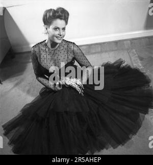 La mode des femmes en 1940s. Une jeune femme dans une robe de soirée typique de 1940s, une robe de soirée de fête noire avec un haut transparent dans un tissu qui voit à travers avec des points décoratifs noirs dessus. Elle est actrice Birgit Tengroth 1915-1983. Suède 1944. Kristoffersson Réf. B145-1 Banque D'Images