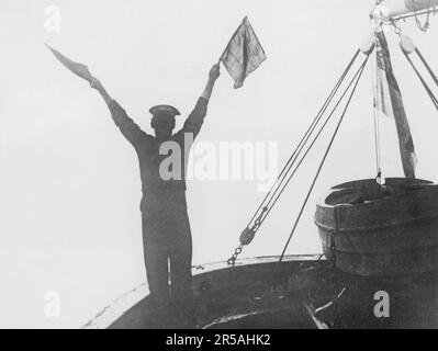 Pendant la Grande Guerre 1914-1918. Un marin a vu la signalisation d'un navire de guerre britannique à un autre. En fonction de la position des deux indicateurs, les combinaisons signifient des lettres et des chiffres différents. L'avantage de l'utilisation de ce système de signalisation manuel était que les messages ne pouvaient pas être entendus, comme lors de la transmission sur fréquence radio. L'inconvénient est que le mauvais temps et la mauvaise vue pourraient rendre difficile la visibilité des drapeaux et du message. 1916 Banque D'Images