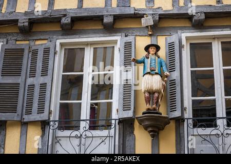 Une statue en bois sculpté et de vieux bâtiments à volets dans le vieux quartier de Quimper, Brittant, France Banque D'Images