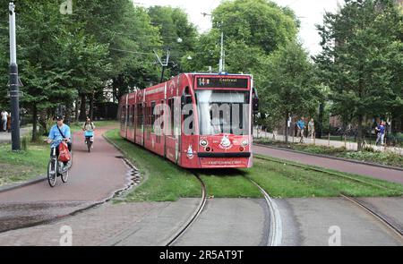 Un tramway serpente à travers Plantage Middenlaan, un couloir de transport vert (lignes de tramway, pistes cyclables et sentiers) à Wertheimpark, Amsterdam. Banque D'Images