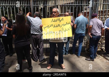 Un homme proteste contre le gouverneur de la Banque centrale libanaise Riad Salameh au Palais de Justice, Beyrouth, Liban, 1 juin 2023. L'affiche se lit comme suit : « les juges libanais apprennent de vos homologues français à poursuivre les criminels et les voleurs ». Le même jour, le Vice-Premier Ministre libanais Saade Chami a demandé la démission de Salameh après que le Gouvernement libanais ait reçu deux avis rouges d'Interpol pour lui. Selon des sources judiciaires, les avis faisaient suite à des mandats d’arrêt émis contre Salameh par des juges français et allemands pour des accusations de blanchiment d’argent, de fraude, de détournement de fonds et d’enrichissement illicite. Salame Banque D'Images