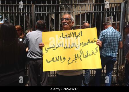 Un homme proteste contre le gouverneur de la Banque centrale libanaise Riad Salameh au Palais de Justice, Beyrouth, Liban, 1 juin 2023. L'affiche se lit comme suit : « les juges libanais apprennent de vos homologues français à poursuivre les criminels et les voleurs ». Le même jour, le Vice-Premier Ministre libanais Saade Chami a demandé la démission de Salameh après que le Gouvernement libanais ait reçu deux avis rouges d'Interpol pour lui. Selon des sources judiciaires, les avis faisaient suite à des mandats d’arrêt émis contre Salameh par des juges français et allemands pour des accusations de blanchiment d’argent, de fraude, de détournement de fonds et d’enrichissement illicite. Salame Banque D'Images