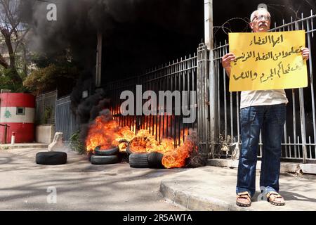 Un homme proteste contre le gouverneur de la Banque centrale libanaise Riad Salameh au Palais de Justice, Beyrouth, Liban, 1 juin 2023. L'affiche se lit comme suit : « les juges libanais apprennent de vos homologues français à poursuivre les criminels et les voleurs ». Le même jour, le Vice-Premier Ministre libanais Saade Chami a demandé la démission de Salameh après que le Gouvernement libanais ait reçu deux avis rouges d'Interpol pour lui. Selon des sources judiciaires, les avis faisaient suite à des mandats d’arrêt émis contre Salameh par des juges français et allemands pour des accusations de blanchiment d’argent, de fraude, de détournement de fonds et d’enrichissement illicite. Salame Banque D'Images