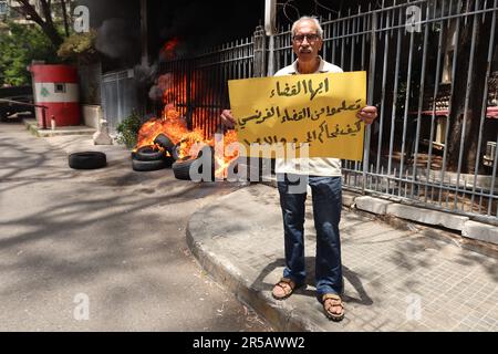 Un homme proteste contre le gouverneur de la Banque centrale libanaise Riad Salameh au Palais de Justice, Beyrouth, Liban, 1 juin 2023. L'affiche se lit comme suit : « les juges libanais apprennent de vos homologues français à poursuivre les criminels et les voleurs ». Le même jour, le Vice-Premier Ministre libanais Saade Chami a demandé la démission de Salameh après que le Gouvernement libanais ait reçu deux avis rouges d'Interpol pour lui. Selon des sources judiciaires, les avis faisaient suite à des mandats d’arrêt émis contre Salameh par des juges français et allemands pour des accusations de blanchiment d’argent, de fraude, de détournement de fonds et d’enrichissement illicite. Salame Banque D'Images