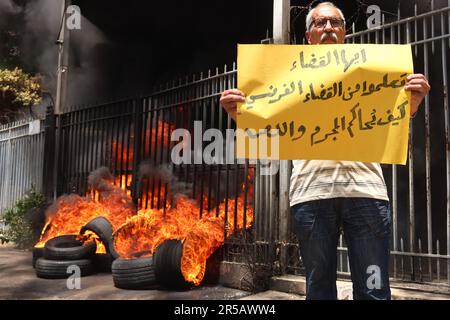 Un homme proteste contre le gouverneur de la Banque centrale libanaise Riad Salameh au Palais de Justice, Beyrouth, Liban, 1 juin 2023. L'affiche se lit comme suit : « les juges libanais apprennent de vos homologues français à poursuivre les criminels et les voleurs ». Le même jour, le Vice-Premier Ministre libanais Saade Chami a demandé la démission de Salameh après que le Gouvernement libanais ait reçu deux avis rouges d'Interpol pour lui. Selon des sources judiciaires, les avis faisaient suite à des mandats d’arrêt émis contre Salameh par des juges français et allemands pour des accusations de blanchiment d’argent, de fraude, de détournement de fonds et d’enrichissement illicite. Salame Banque D'Images