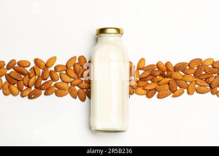 Une bouteille de lait d'amande et d'amandes sur fond blanc dans une vue de dessus Banque D'Images