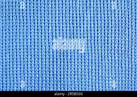 Fragment de vêtements tricotés bleus de tricot rugueux. Arrière-plan pour la conception, la mise en page Banque D'Images