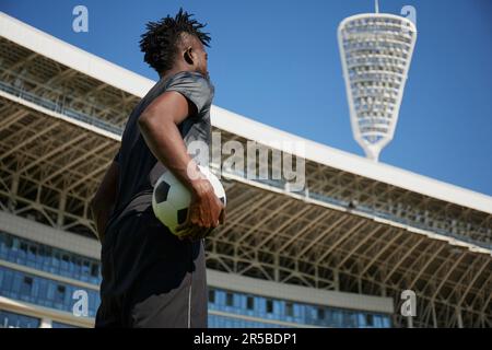 Joueur de football afro-américain en entraînement. Jambes de footballeur en herbe Banque D'Images