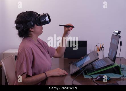 Femme artiste de réalité virtuelle. Développeur portant un casque VR Créer du contenu. Elle travaille dans un studio de création. Banque D'Images