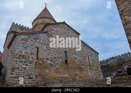 Une ancienne église entourée de majestueuses structures de pierre se dresse fièrement au sommet d'une colline, créant un paysage incroyablement beau Banque D'Images