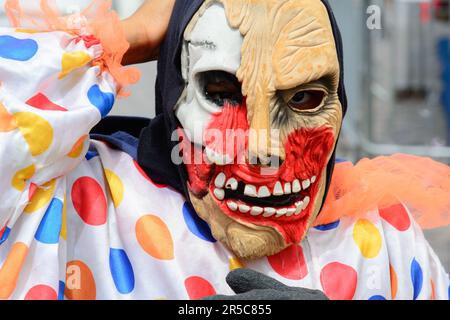 Un clown souriant portant un nez rouge traditionnel et un visage peint en blanc et orange Banque D'Images