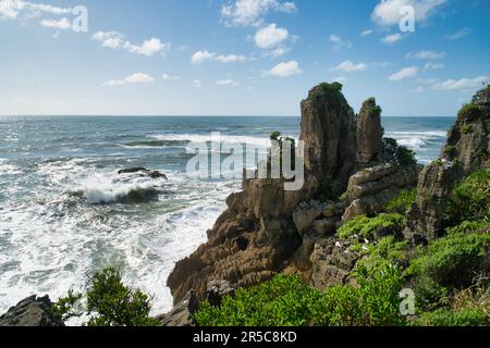 Une vue aérienne tranquille d'une plage sereine montrant la vaste étendue de l'océan, avec des rochers et une végétation luxuriante entourant l'île pittoresque Banque D'Images