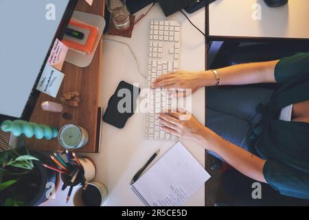 J'ai de grandes attentes pour mon entreprise. Photo en grand angle d'une femme méconnaissable assise seule et utilisant son ordinateur pour travailler de chez elle. Banque D'Images