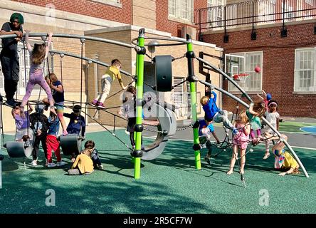 Les enfants s'amusent dans une salle de gym de la jungle dans un terrain de jeu de l'école élémentaire de Brooklyn, New York. Banque D'Images