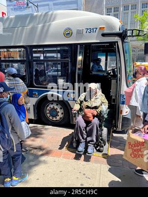 Les bus NYC sont équipés pour accueillir les personnes handicapées en fauteuil roulant avec des rampes d'accès en mode reflex pour monter et descendre du bus. Banque D'Images