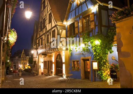 Cave de vinification et maisons à colombages dans la soirée Riquewihr, Alsace, France Banque D'Images