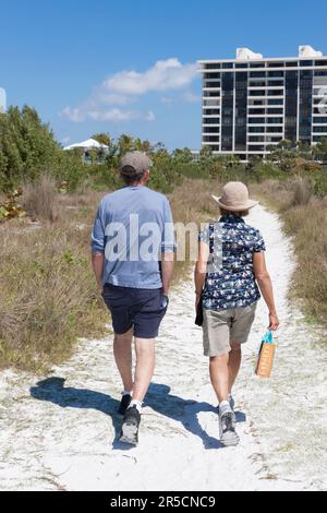 Couple marié, en vacances, marche sur le chemin de la plage à Siesta Key, Sarasota, Floride, États-Unis. Banque D'Images