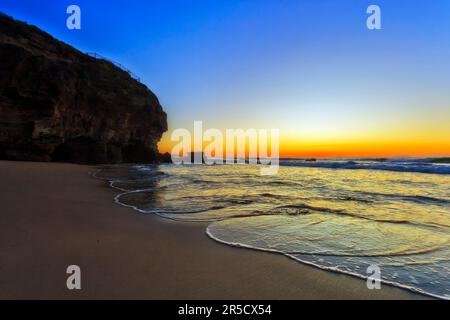 Ascension panoramique à ciel clair au-dessus de l'horizon de l'océan Pacifique depuis les grottes marines de la plage de Caves en Australie. Banque D'Images