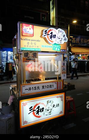 Stand de pancakes au marché de nuit touristique de Huaxi Street à Taipei, Taïwan; chariot et vendeur de nourriture de rue; cuisine traditionnelle taïwanaise. Banque D'Images