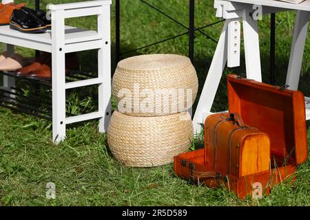 Paniers et valises en osier sur l'herbe près du porte-chaussures à l'extérieur. Vente de garage Banque D'Images