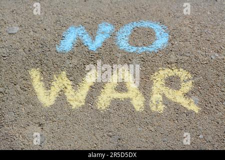 Mots No War écrit avec des craies bleues et jaunes sur l'asphalte à l'extérieur Banque D'Images