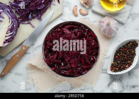 Choucroute au chou rouge et ingrédients savoureux sur table en marbre blanc, plat Banque D'Images