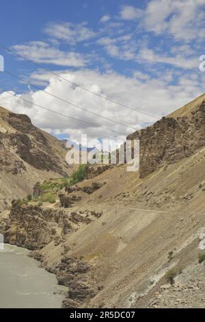 Belle vue de la rivière qui coule entre les montagnes rocheuses avec des nuages dans le ciel sur le chemin de Padum, Zanskar, Ladakh, INDE Banque D'Images