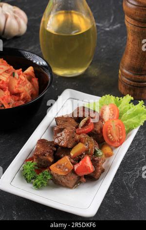 Steak de bœuf Saikoro coupé en dés avec sauce Bulgogi, servi avec des kimchi coréens Banque D'Images