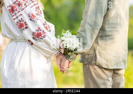 Jeune couple ukrainien en chemises nationales brodées tenant les mains. Homme et femme Ouydoor. Amoureux, famille, confiance, amour et bonheur. Ukraine Banque D'Images