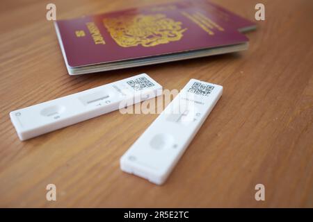 Vue rapprochée de deux passeports britanniques avec deux tests COVID montrant des résultats négatifs. Banque D'Images