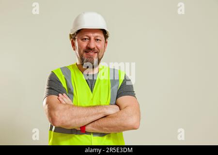 Un homme travailleur dans un gilet et un casque de construction blanc dans différentes poses se tient sur un fond blanc Banque D'Images