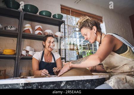 Explorer leur côté créatif à travers l'argile. deux jeunes femmes travaillant avec de l'argile dans un studio de poterie. Banque D'Images