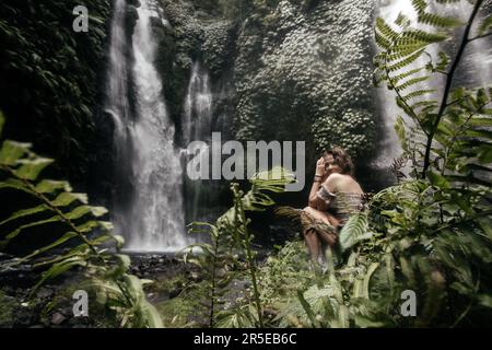 Jeune femme routard près de la cascade dans les jungles. Banque D'Images