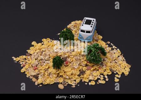 Un îlot avec une fourgonnette blanche et bleue garée entre les arbres sur un fond noir. Scène de style de vie minimale. Banque D'Images