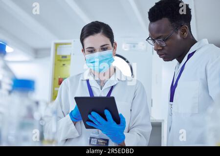 Science, personnel et homme avec femme, tablette et connexion dans un laboratoire, recherche de virus ou médical. Collègues, chercheurs ou employées de sexe féminin Banque D'Images