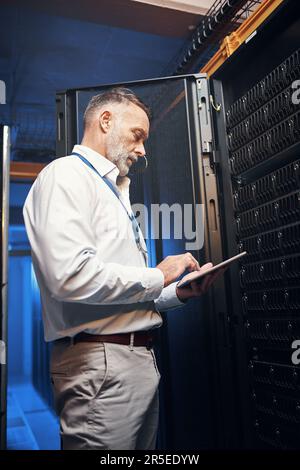 Donnez à votre entreprise les moyens d'accéder à Internet haut débit. homme mature utilisant une tablette numérique tout en travaillant dans une salle de serveurs. Banque D'Images