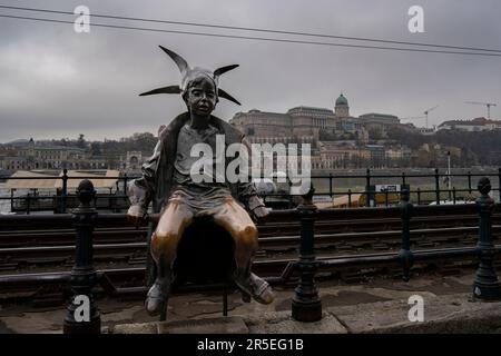 Budapest, Hongrie - 29 novembre 2022 : la statue de la petite princesse sur les rails de la promenade du Danube, un jour d'hiver couvert. Banque D'Images