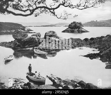 Vue de la fin du 19th siècle sur les touristes et un bateau à côté de l'île Otter dans la baie de Bantry près de Glengarriff, un village sur la péninsule de Beara du comté de Cork, en Irlande. Banque D'Images