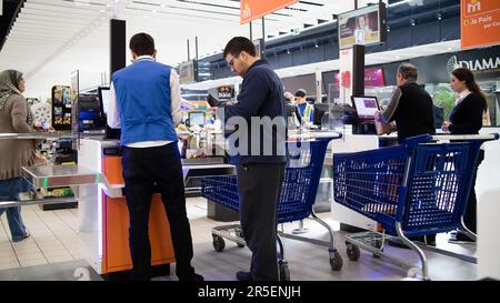 Les clients qui reçoivent de l'aide à la caisse libre-service dans un supermarché Banque D'Images
