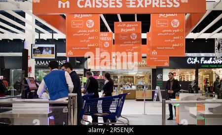 Le personnel du supermarché guide les clients à travers les caisses libre-service Banque D'Images