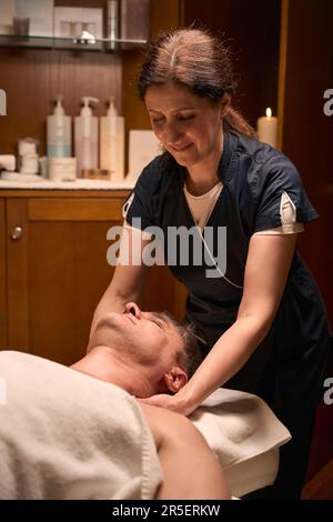 Médecin ostéopathique effectuant une manipulation du rachis cervical sur le patient Banque D'Images