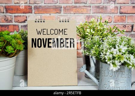 Message texte de bienvenue de novembre avec plante artificielle en métal décoration vase Banque D'Images