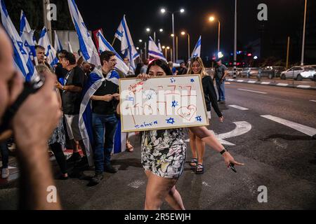 Hadera, Israël. 03rd juin 2023. Un partisan de Benjamin Netanyahu porte un signe qui se lit comme « le roi Bibi » et « les gauchistes sont des maniaques » pendant la manifestation. Des policiers israéliens ont réprimé les manifestants contre la réforme judiciaire qui a fait la preuve devant le poste de police d'Hadera pour soutenir les manifestants qui ont été arrêtés à côté de la maison du Premier ministre Benjamin Netanyahu à Césarée. Crédit : SOPA Images Limited/Alamy Live News Banque D'Images