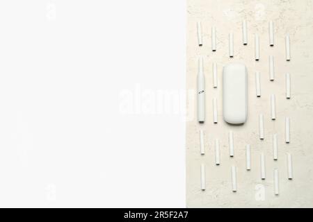 Composition avec un cigare électronique moderne et de nombreux bâtons sur une table blanche Banque D'Images