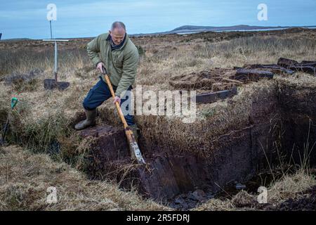 Cutter de tourbe à l'œuvre sur les rives du Loch Gorm à Islay, en Écosse Banque D'Images