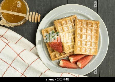 Gaufres fraîches sur la table, gaufres belges fraîches. Arrière-plan en bois, espace de copie. Délicieuses gaufres belges faites maison au sirop ou au miel, swee Banque D'Images